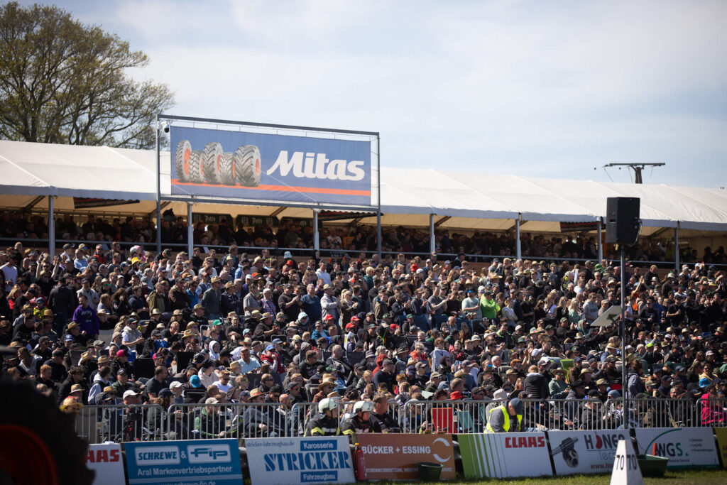 Hütte voll beim Tractor Pulling Füchtorf: Tausende Zuschauer auf den Tribünen verfolgen das Event, überragt von einem Mitas-Reifen-Werbebanner.