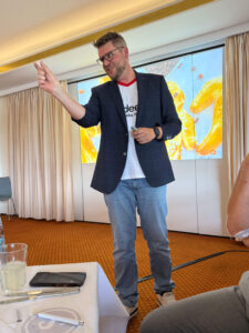 Andreas Duck als Speaker beim 2. Münster Netzwerk-Impuls von SUCCESS 21, im Fußballtrikot vor der Vortragsfolie